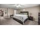 Spacious main bedroom featuring dark wood furniture, ceiling fan, neutral carpet, and walk-in closet entrance at 380 Ne 53Rd St, Ocala, FL 34479