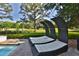 Serene backyard lounging area with unique seating near the pool and golf green at 4026 Nw 85Th Ter, Ocala, FL 34482