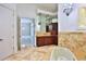 Luxurious bathroom showcasing marble flooring, cabinetry with mirrors, and an elegant chandelier fixture at 4026 Nw 85Th Ter, Ocala, FL 34482