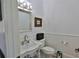 Elegant powder room features a pedestal sink, wainscoting, and decorative mirror at 4026 Nw 85Th Ter, Ocala, FL 34482