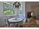 Cozy breakfast nook area with a round table, seating for six, large windows with a chandelier and exterior view at 4026 Nw 85Th Ter, Ocala, FL 34482