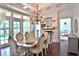 Bright dining room with hardwood floors and a large table set for eight people and large windows with exterior views at 4026 Nw 85Th Ter, Ocala, FL 34482