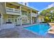 Back exterior view showcasing the pool, brick patio, and multi-story home with balconies at 4026 Nw 85Th Ter, Ocala, FL 34482