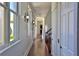 Hallway illuminated by stylish sconces, featuring hardwood floors and views of the outdoors through windows at 4026 Nw 85Th Ter, Ocala, FL 34482