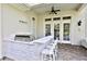 Outdoor kitchen with a built-in grill and bar seating on the covered patio at 4026 Nw 85Th Ter, Ocala, FL 34482