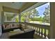 Relaxing covered patio featuring comfortable seating with views of the lush golf course and pond at 4026 Nw 85Th Ter, Ocala, FL 34482