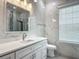 Bathroom featuring marble walls, cabinet, and a large sink next to a toilet at 4370 County Road 121D, Wildwood, FL 34785