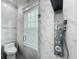 Modern bathroom with marble tile, a shower panel with multiple spray heads, and a window at 4370 County Road 121D, Wildwood, FL 34785