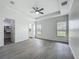 Spacious bedroom features gray wood floors, a tray ceiling, and windows with blinds at 4370 County Road 121D, Wildwood, FL 34785