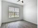 Clean, minimalist bedroom with hard floors, a ceiling fan, and a bright window at 4370 County Road 121D, Wildwood, FL 34785