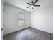 Bedroom featuring a ceiling fan, hardwood floors, and a window with blinds at 4370 County Road 121D, Wildwood, FL 34785