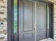 Elegant double front doors with sidelights and modern hardware, surrounded by stone accents at 4370 County Road 121D, Wildwood, FL 34785