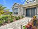 Stunning home entrance featuring a paved walkway, stone accents, and beautiful landscaping at 4370 County Road 121D, Wildwood, FL 34785