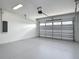 Spacious garage with a roll-up door, new paint, and updated overhead lighting at 4370 County Road 121D, Wildwood, FL 34785