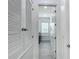 Bright hallway with cabinets leads to the laundry room showcasing modern appliances at 4370 County Road 121D, Wildwood, FL 34785