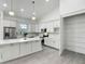 Modern white kitchen with stainless steel appliances, quartz countertops, and spacious pantry at 4370 County Road 121D, Wildwood, FL 34785