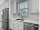Kitchen features stainless steel appliances, white cabinets, quartz countertops and a stylish backsplash at 4370 County Road 121D, Wildwood, FL 34785