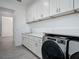 Laundry room featuring white cabinets, quartz counters, and modern Whirlpool washer and dryer at 4370 County Road 121D, Wildwood, FL 34785