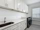 Laundry room boasts white cabinetry, quartz countertops, and modern washer and dryer at 4370 County Road 121D, Wildwood, FL 34785