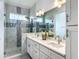 Stylish bathroom featuring double vanity, marble accents, and a glass-enclosed shower at 4370 County Road 121D, Wildwood, FL 34785