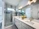 Elegant bathroom with double sinks, quartz counters, and glass-enclosed shower at 4370 County Road 121D, Wildwood, FL 34785