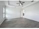 Bright primary bedroom with tray ceilings, fan, and wood-look floors at 4370 County Road 121D, Wildwood, FL 34785
