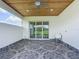 Covered patio with patterned tile, wood ceiling, outdoor sink, and sliding glass doors at 4370 County Road 121D, Wildwood, FL 34785