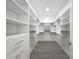 Walk-in closet with custom white shelving and drawers for optimal storage at 4370 County Road 121D, Wildwood, FL 34785