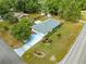 Overhead view of a single-story home with a long driveway, manicured landscaping, and mature trees on a quiet street at 4880 Ne 23 Ave, Ocala, FL 34479