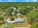 Expansive aerial view of a charming single-story home nestled among mature trees in a quiet neighborhood at 4880 Ne 23 Ave, Ocala, FL 34479