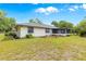 View of home's exterior with blue trim, tidy landscaping, and screened porch at 4880 Ne 23 Ave, Ocala, FL 34479