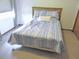 Cozy bedroom featuring a comfortable bed with striped bedding and natural light from the window at 5083 Se 26Th St, Ocala, FL 34480