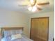 Bright bedroom showcases a ceiling fan, a comfortable bed, and a closet for ample storage at 5083 Se 26Th St, Ocala, FL 34480