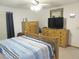Bright bedroom features a ceiling fan, dresser, and a comfortable bed with blue and white striped bedding at 5083 Se 26Th St, Ocala, FL 34480