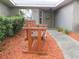 A close-up of a wooden bench in front of a home's entrance, complemented by a welcoming walkway at 5083 Se 26Th St, Ocala, FL 34480