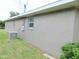 The home's exterior wall and yard featuring neutral stucco, an AC unit, and well-maintained green lawn at 5083 Se 26Th St, Ocala, FL 34480