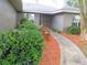 A cozy bench nestled amid lush bushes, mulch, and a welcoming stone path lead to the front entrance at 5083 Se 26Th St, Ocala, FL 34480