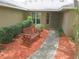 Close up of a inviting front entrance with a charming bench and well manicured shrubbery at 5083 Se 26Th St, Ocala, FL 34480
