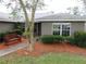 Charming front entrance with a bench surrounded by manicured bushes, a stone walkway, and fresh mulch at 5083 Se 26Th St, Ocala, FL 34480