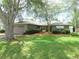 A well-manicured lawn, mature trees, and a bench complement this charming single-story home's exterior at 5083 Se 26Th St, Ocala, FL 34480