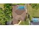 Aerial view of a home showcasing a screened-in pool, large backyard, mature trees, and large roof at 5174 Se 41St Ave, Ocala, FL 34480