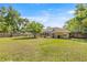 View of large backyard with mature trees and screened pool and backyard at 5174 Se 41St Ave, Ocala, FL 34480