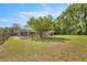 View of large backyard, screened pool, mature trees, and outdoor seating area at 5174 Se 41St Ave, Ocala, FL 34480