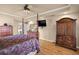 Spacious main bedroom featuring a four-poster bed, wood floors and a TV at 5174 Se 41St Ave, Ocala, FL 34480
