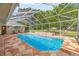 Bright in-ground screened pool boasts stone-look patio, water feature and outdoor seating area for relaxing by the water at 5174 Se 41St Ave, Ocala, FL 34480