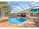 Bright in-ground screened pool boasts stone-look patio, water feature and outdoor seating area at 5174 Se 41St Ave, Ocala, FL 34480