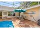 Outdoor patio with stone-look paving includes seating and dining area for enjoying a meal by the pool at 5174 Se 41St Ave, Ocala, FL 34480