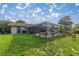 Backyard featuring a screened pool, landscaping, and a home with a light exterior at 5720 Se 20Th St, Ocala, FL 34480
