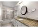 Updated bathroom features granite countertops, a large mirror, and a glass-enclosed shower at 5720 Se 20Th St, Ocala, FL 34480