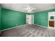 Spacious bedroom with green walls, a ceiling fan, and access to an ensuite bathroom and kitchen at 5720 Se 20Th St, Ocala, FL 34480